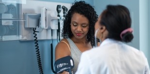 A doctor performs a blood pressure screening for a person with diabetes