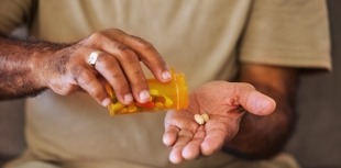 An older person takes their medication