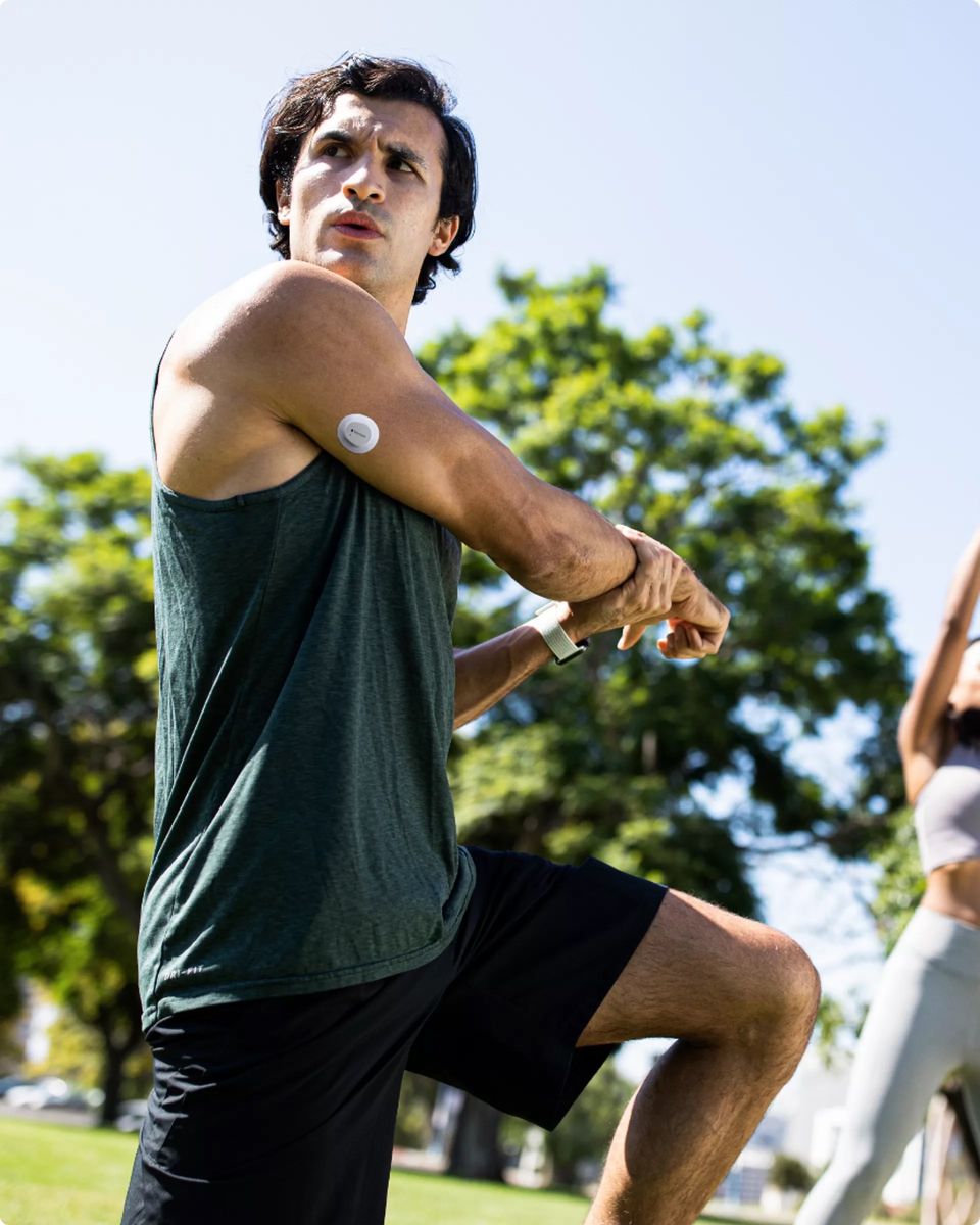 A person stretches while wearing a Dexcom G7 CGM