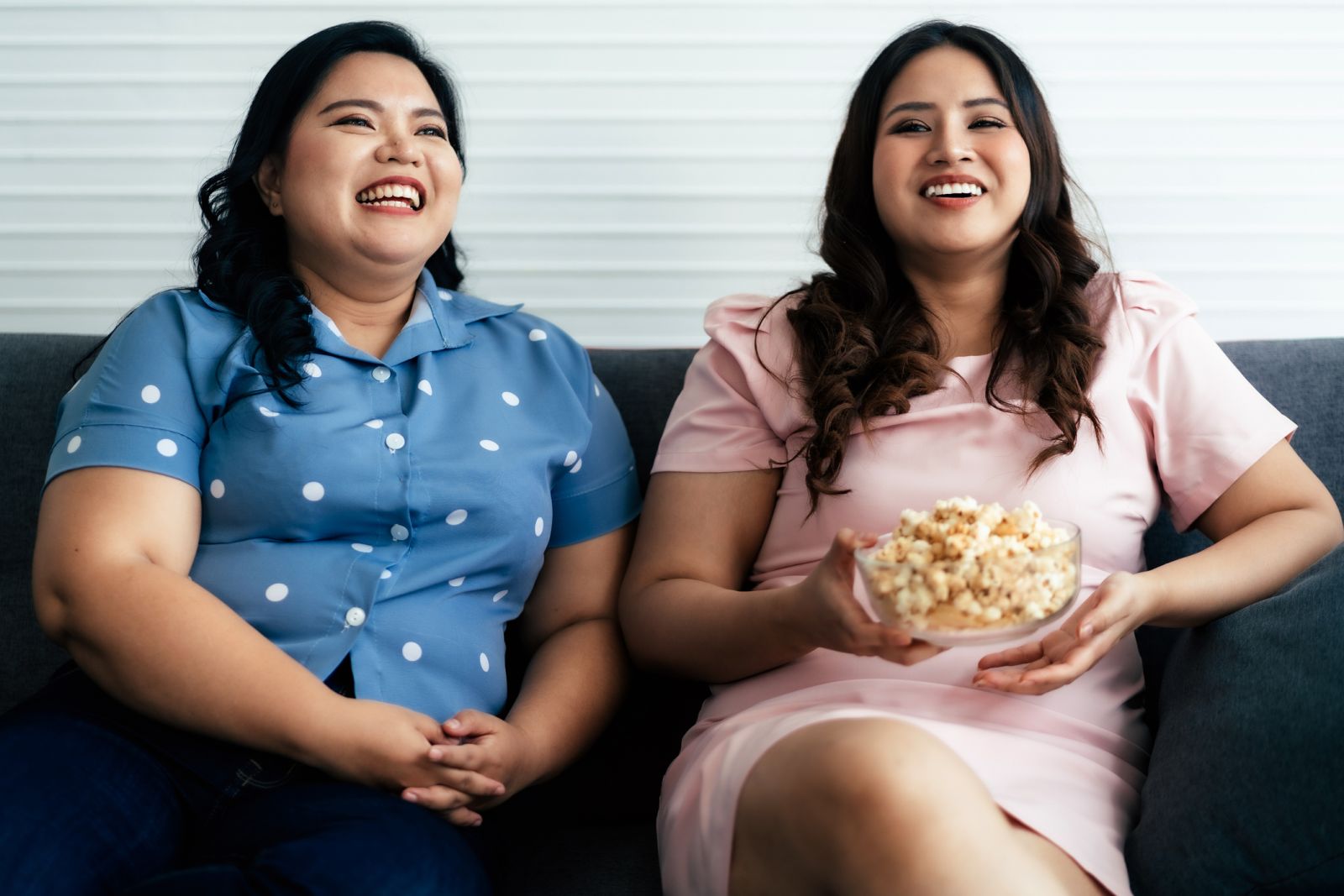 Women with obesity enjoy some popcorn while watching a movie