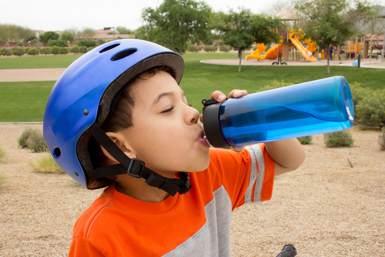 A boy drinks from a water bottle