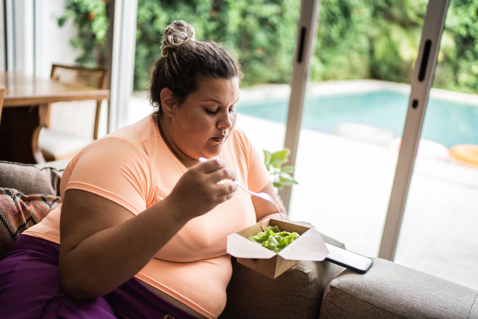 A person with obesity eating a salad