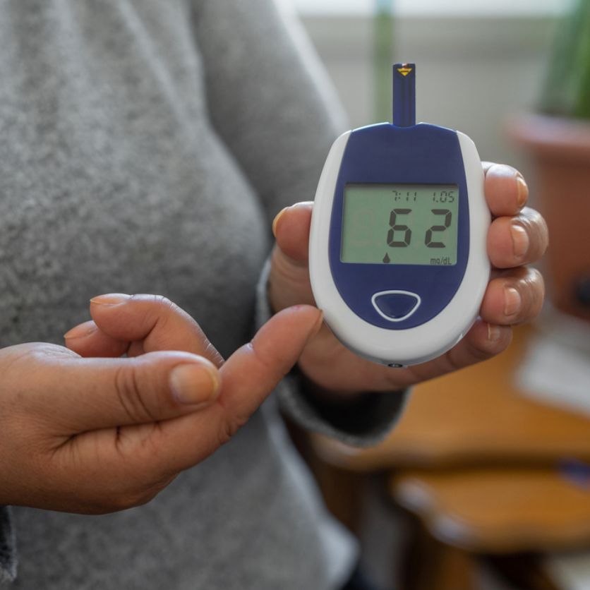 Woman holding glucometer with low blood sugar reading