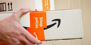 A person holds a package delivery from Amazon