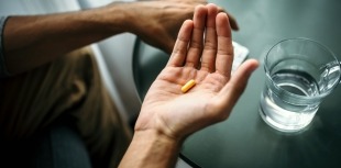 A person holds a pill