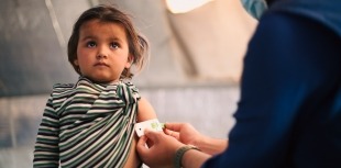 Doctor examines child in refugee camp
