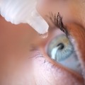 A person receives eye drop treatment