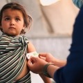 Doctor examines child in refugee camp