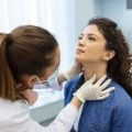 A woman is examined for thyroid disease